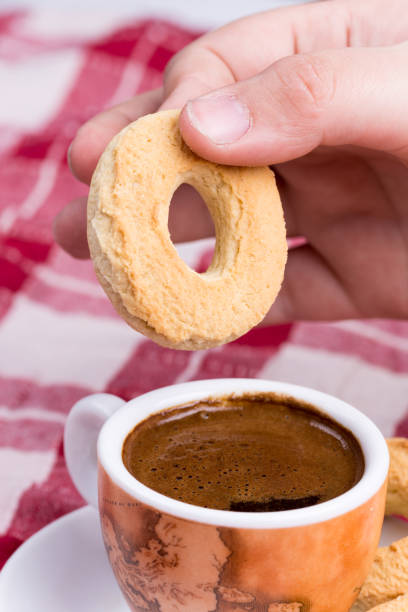 istock Hand dipping round cookie in to coffee cup 1220945743