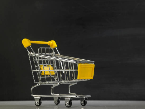 istock mini shopping cart against blackboard 1220949758