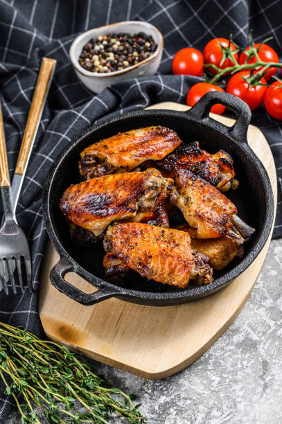 istock Baked glazed chicken wings in a pan. Gray background. Top view 1220952143