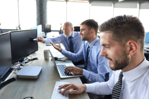 istock Group of young business men in formalwear working using computers while sitting in the office. 1220952545