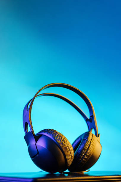 istock headphones illuminated by multi-colored fires on a bright colored background. 1220953042