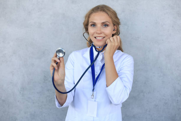 felice medico donna sorridente in uniforme bianca e stetoscopio, isolato su sfondo grigio. - 7096 foto e immagini stock