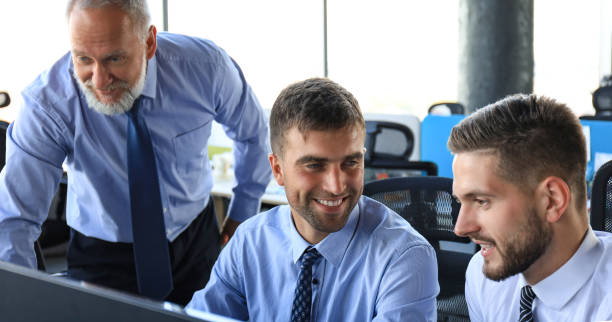 istock Group of young business men in formalwear working using computers while sitting in the office. 1220954217