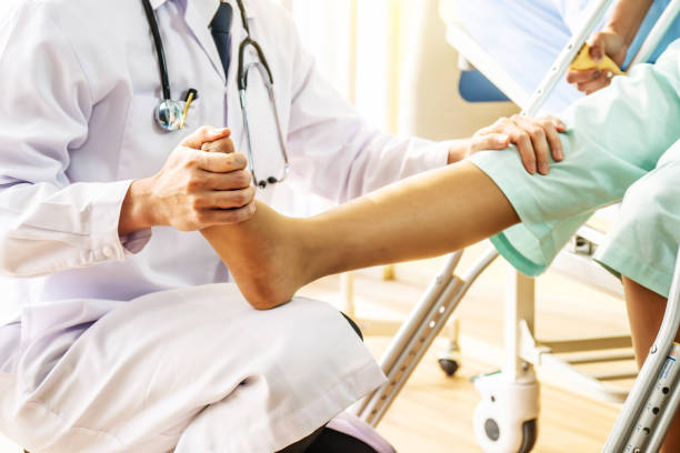 医師と患者 - 医師は膝から脚を調べ、足首と病院で骨折した脚の患者を訓練 - 理学療法の概念 - medicine cabinet 写真 ストックフォトと画像