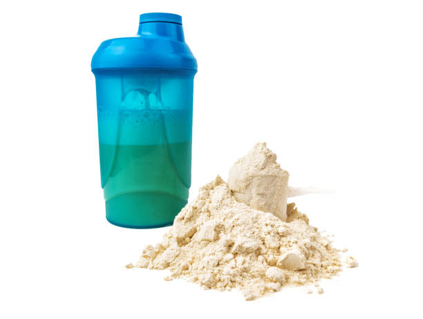 istock heap of protein and blue shaker on white 1220958388