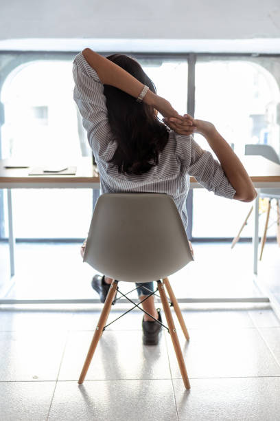 istock Business woman taking a moment for relax and stretching in the office. Back view. 1220958607