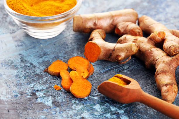istock Turmeric powder and fresh turmeric on table 1220960471