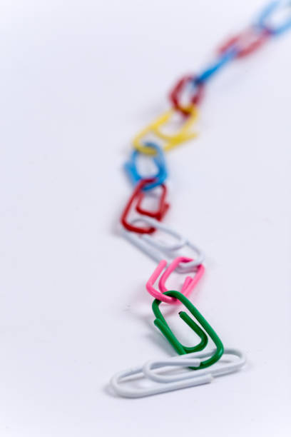 istock Colorful metal paperclips over white background 1220967829