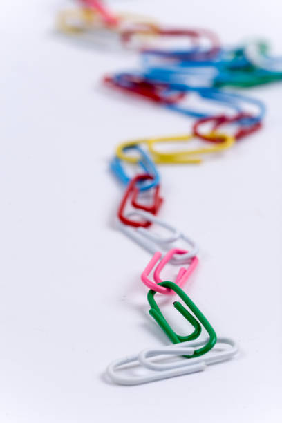 istock Colorful metal paperclips over white background 1220967840