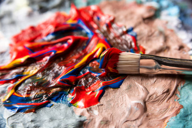 miscelazione della vernice sulla tavolozza dei dipinti - paint mixing stick foto e immagini stock