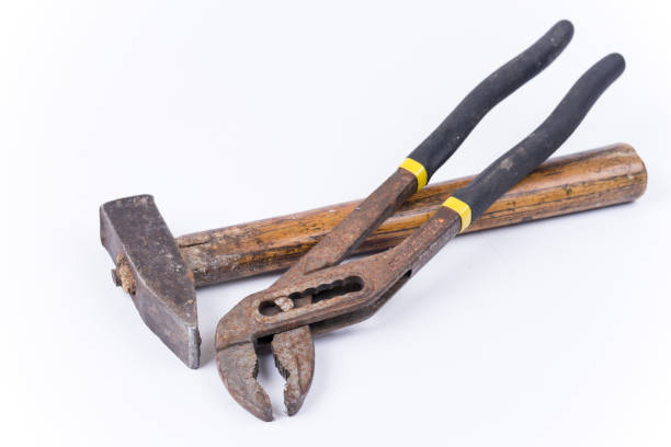istock Old used hammer with metal pliers over white 1220968818