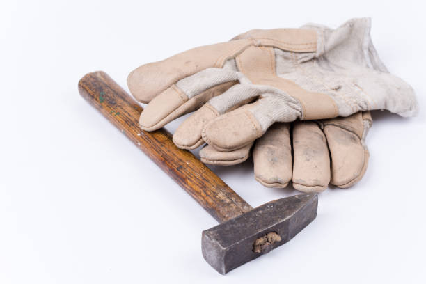 istock Old dirty hammer with used working leather gloves 1220968822