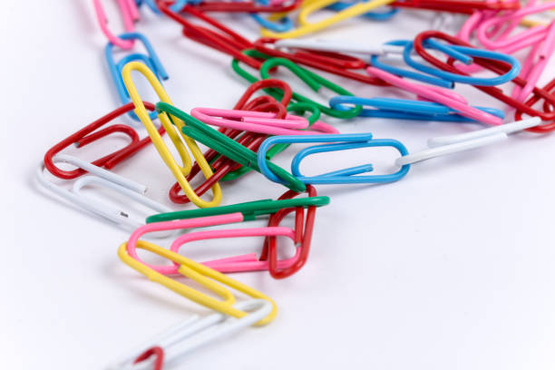 Colorful metal paperclips over white background.