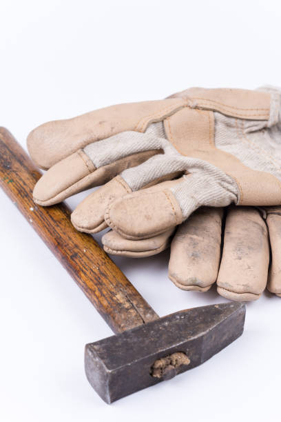 istock Old dirty hammer with used working leather gloves 1220969412