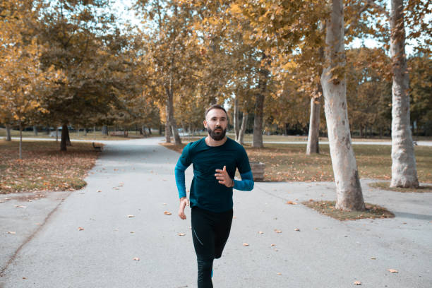 istock Professional athlete jogging in public park 1220971249