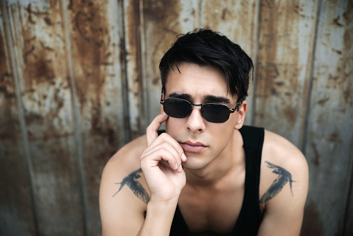 Young tattooed man wearing sunglasses outdoors