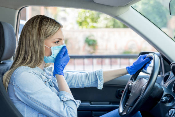 istock Woman wearing a face mask in a car. 1220971852