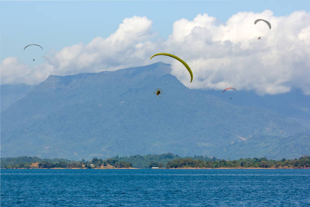 istock Parachute Flying over Water surface With Background Mountains Trees And Mist On a clear day in Laos. at Nam Ngum Dam Laos 1220971893