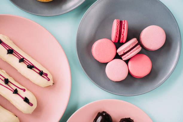 Pink macaroons and eclairs flatlay stock photo