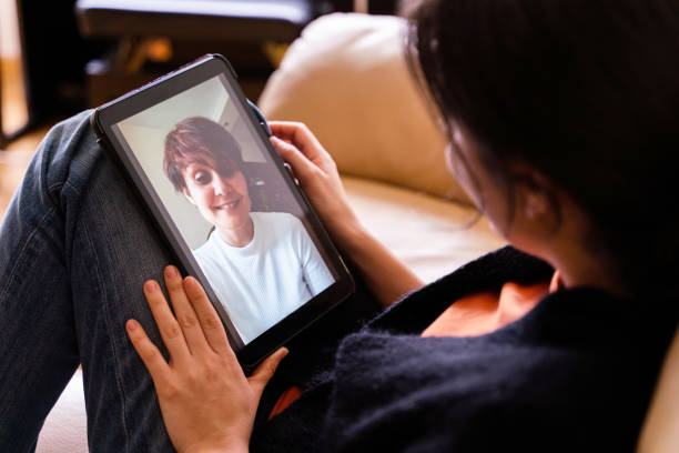 istock Cheerful woman calling a friend with tablet device. 1220973977