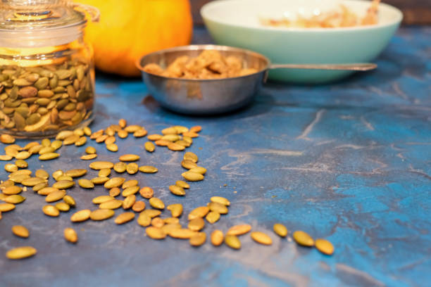istock Pumpkin seeds, toasted pumpkin seeds, in Minsk on a dark blue table. 1220974295
