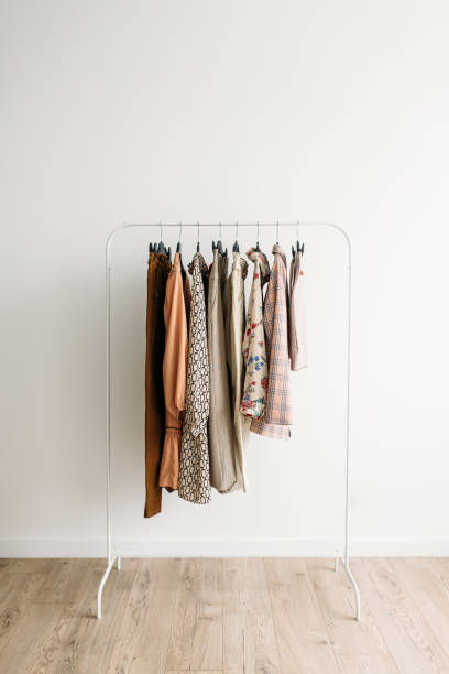 Rack with capsule clothes in beige colors stock photo
