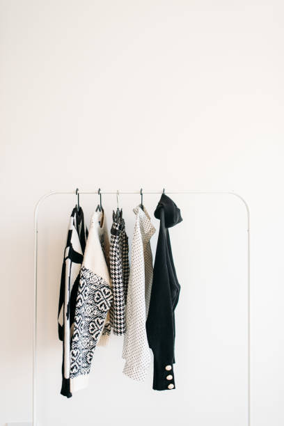 Rack with capsule clothes in black and white colors closeup stock photo