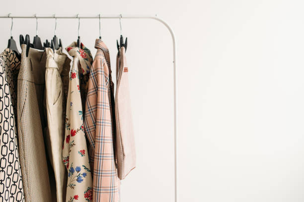 Rack with capsule clothes in beige colors closeup stock photo