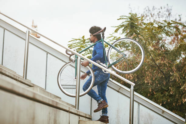 istock Commuter in Early 30s Carrying Bicycle Up Stairs After Work 1220975301