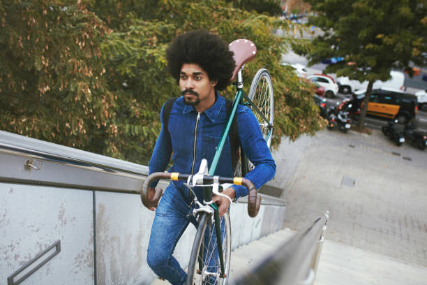 istock Afro-Caribbean Male Commuter Carrying Bicycle Up Staircase 1220975313