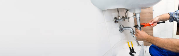 istock Male Plumber Fixing Sink In Bathroom 1220975409