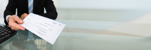 istock Midsection Of Businessman Giving Cheque 1220975449