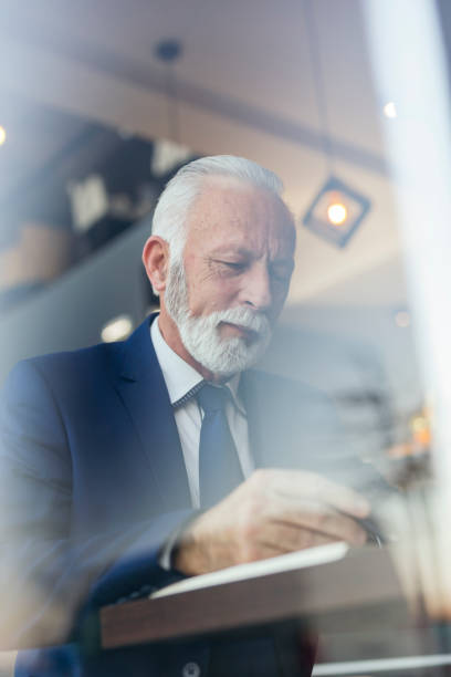 istock Senior businessman writing in a planner 1220975529