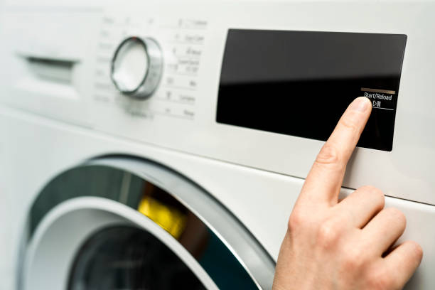 istock Close up of woman choosing cycle program on washing machine 1220975652