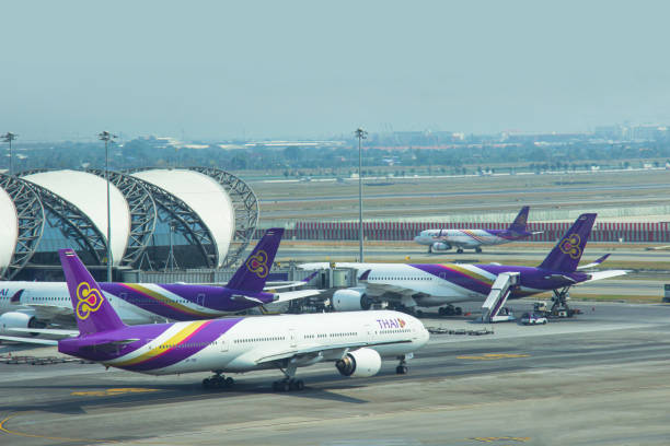 bangkok, tajlandia - 10 marca 2020: samoloty thai airways (tg) są zaparkowane w swoim węźle przy bramie pasażerskiej, łączą się z bramą wewnątrz międzynarodowego lotniska suvarnabhumi samutprakan. tajlandia. - thai airways zdjęcia i obrazy z banku zdjęć