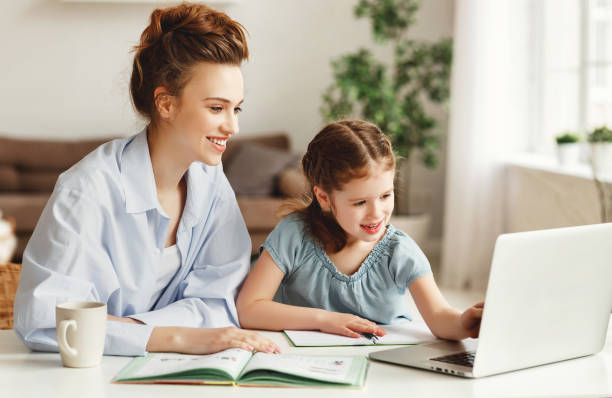 ragazza felice con la madre che studia online a casa - 13451 foto e immagini stock