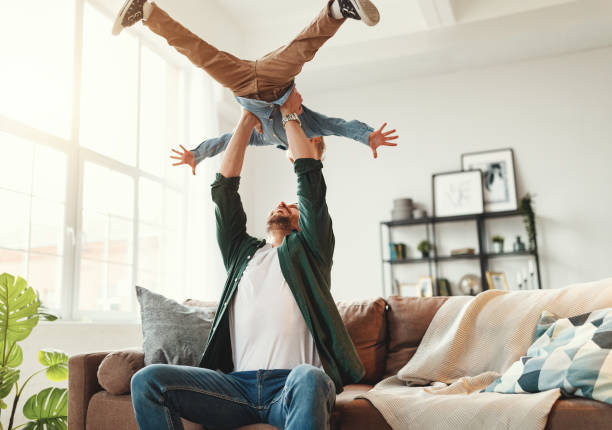 istock Happy man having fun with son at home 1220984522