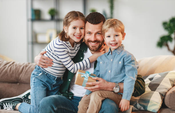 istock Little siblings congratulating happy father at home 1220984911
