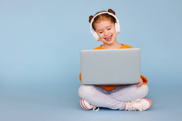 istock Cheerful girl in headphones using laptop 1220985503