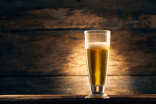 Beer into the glass on wooden background
