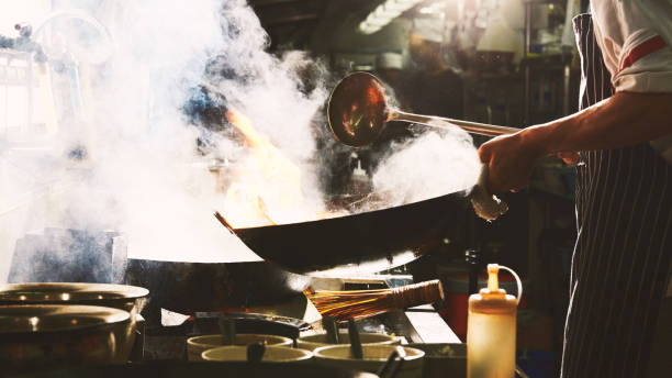 istock Chef stir fry in wok 1220986965