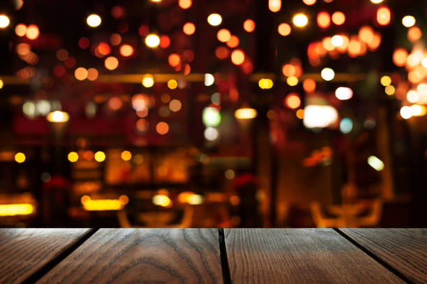 oskärpa bokeh av bar part mörk natt ljus bakgrund med trä bord bakgrund - julfika bildbanksfoton och bilder