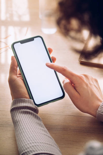 manos de una mujer usando un teléfono móvil con una pantalla en blanco (copiar espacio), un - telephone dialing human hand office fotografías e imágenes de stock