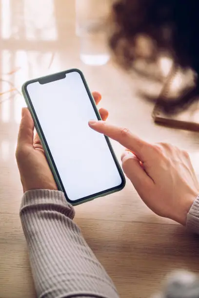 Photo of Hands of a Woman Using a Mobile Phone With a Blank Screen (Copy Space), a Close Up