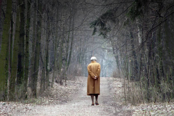 staruszka chodząca po leśnym stylu życia. depresja, nieszczęśliwy i ból w cofającej się sylwetce chorej osoby starszej. - retirement pension hourglass concepts zdjęcia i obrazy z banku zdjęć