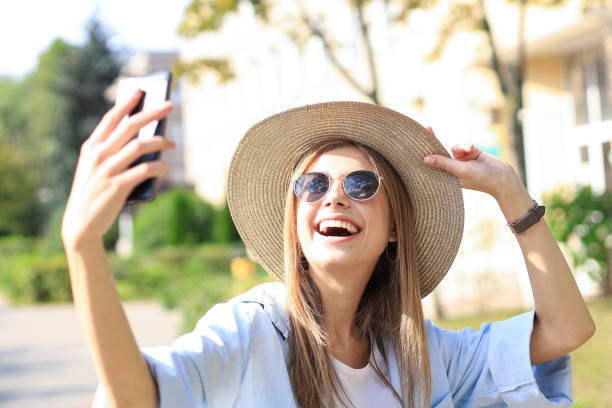 istock Beautiful young blonde girl using mobile phone while standing outdoors. 1220988533