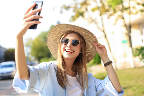 istock Beautiful young blonde girl using mobile phone while standing outdoors. 1220988555