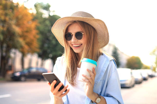 istock Beautiful young blonde girl using mobile phone while standing outdoors. 1220988708