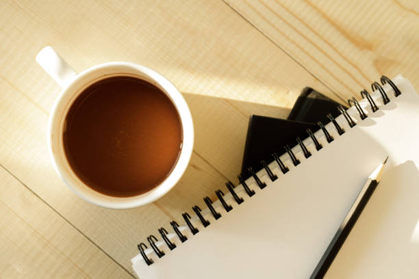 istock cup of hot chocolate on wooden background with notebook.  Work from home concept. 1220988928