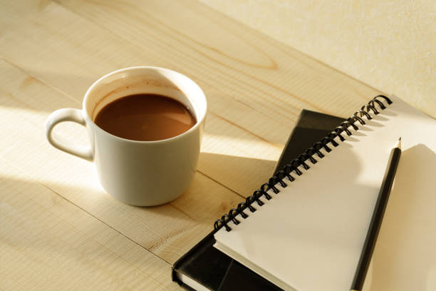 istock cup of hot chocolate on wooden background with notebook.  Work from home concept. 1220988933